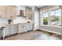 Stylish kitchen with a gas stovetop, modern range hood, bright window, and sleek countertops at 1028 Seven Sisters Ave, Monroe, NC 28110