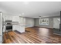 Stylish kitchen open to the living room, featuring stainless steel appliances, granite countertops, and hardwood floors at 118 Alfara Ln, Troutman, NC 28166