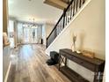 Inviting foyer with wood floors, staircase, and a view into the living room with French doors at 12217 Greymore Ct, Charlotte, NC 28277