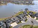 An aerial view of lakefront homes with well-manicured yards and a lake in the background at 126 Sisters Cove Ct, Mooresville, NC 28117