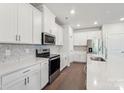 Modern kitchen featuring white cabinets, stainless steel appliances, and stylish marble backsplash at 138 Satchel Ct, Mooresville, NC 28115