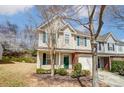 Townhome with light siding, brick facade, a green door, and attached garage at 16729 Timber Crossing Rd, Charlotte, NC 28213