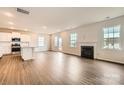 Open-concept living room featuring hardwood floors, recessed lighting, and a modern fireplace at 1816 Otter Perch Ln, Fort Mill, SC 29715