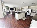 Open-concept kitchen with a center island, white cabinetry, and dark countertops adjacent to living area at 269 Loch Stone St, Fort Mill, SC 29715