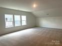 Spacious bedroom featuring multiple windows, neutral carpeting and a large open layout at 324 Basil Dr, Indian Trail, NC 28079