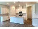 Bright kitchen with white cabinets, stainless steel appliances, and a spacious island with a sink at 324 Basil Dr, Indian Trail, NC 28079
