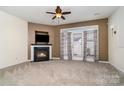 Bright living room with a fireplace, ceiling fan, and french doors to bring natural light at 4028 Center Place Dr, Harrisburg, NC 28075
