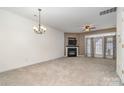 Open living room with modern ceiling fan, fireplace, and views to the kitchen area at 4028 Center Place Dr, Harrisburg, NC 28075