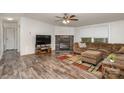 The cozy living room showcases a stone fireplace, a large window, and wood-look floors at 6106 Ashley Dr, Concord, NC 28025