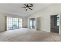 Bright living room with large windows, neutral carpet, ceiling fan, and open doorway to adjacent rooms at 657 Heathridge Rd, Rock Hill, SC 29732