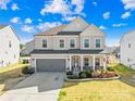 Charming two-story home featuring a well-manicured lawn, a gray two-car garage, and a welcoming front porch at 7314 Rupell Dr, Charlotte, NC 28273