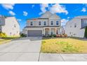 Beautiful two-story home featuring a gray two-car garage, a charming front porch, and landscaped yard at 7314 Rupell Dr, Charlotte, NC 28273