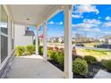 View from the porch with white pillars, nice landscaping, and a glimpse of the neighborhood at 7314 Rupell Dr, Charlotte, NC 28273