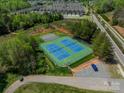 Aerial view of a tennis court and a parking lot surrounded by trees at 113 Burlingame Ct # C, Mooresville, NC 28117