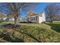 Landscaped yard with a tree, complemented by the home's neutral siding and classic architectural details at 114 Indian Paint Brush Dr, Mooresville, NC 28115