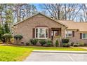 Traditional brick home with mature trees, lush lawn, and a neatly paved walkway at 1202 Ravenwood Ct, Salisbury, NC 28147