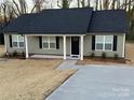 Inviting single-story house features a black front door framed by white columns and newly installed dark roof at 1311 Meadow Ave, Kannapolis, NC 28083