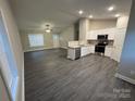 Open concept living room flowing into a modern kitchen with gray floors and ample natural light at 1311 Meadow Ave, Kannapolis, NC 28083