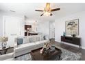 Bright living room with hardwood floors, ceiling fan, and view into the modern kitchen at 1509 Harrill St, Charlotte, NC 28205