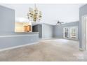 Spacious living room with French doors, ceiling fan and open view to the adjacent kitchen at 16312 Redstone Mountain Ln, Charlotte, NC 28277