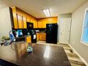 Well-lit kitchen boasts granite countertops, black appliances, and wood-look flooring at 207 Sigmon Rd, Statesville, NC 28677