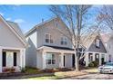 View of the exterior of a charming gray two-story home, landscaped yard and covered porch at 232 Faust Rd, Davidson, NC 28036