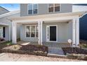 Front exterior featuring a black front door, white columns, and a small rock garden at 232 Faust Rd, Davidson, NC 28036