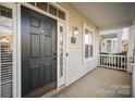 Welcoming front porch featuring a dark wood door, sidelight windows, and brick foundation at 4108 Twenty Grand Dr, Indian Trail, NC 28079