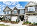 Beautiful new townhome with stone details, siding, a one-car garage, and landscaping at 4223 Black Ct # 195, Harrisburg, NC 28075