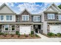 Charming new townhome with a mix of stone, gray siding, and one-car garage at 4223 Black Ct # 195, Harrisburg, NC 28075