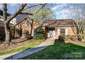 Charming single-story brick home with mature landscaping, a walkway, and a welcoming entrance at 4309 Woodglen Ln, Charlotte, NC 28226