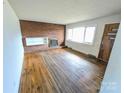 Bright living room with hardwood floors, a brick fireplace, and a large window with plenty of natural light at 4801 Kipling Dr, Charlotte, NC 28212