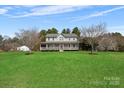 Beautiful home with a welcoming front porch, nestled on a large lot with mature trees and a green lawn at 534 Stewart Rock Rd, Stony Point, NC 28678