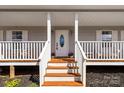 Inviting front porch with wooden steps, white railings, and a decorative front door with sidelights at 534 Stewart Rock Rd, Stony Point, NC 28678