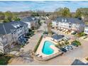 Aerial view of townhome community featuring a swimming pool and well-manicured landscaping and ample parking at 6724 Mallard Park Dr, Charlotte, NC 28262