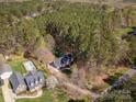 Aerial view of property showcasing the home, pool, landscaping, and surrounding wooded area at 7025 Ridgeway Rd, Stanley, NC 28164