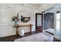 Bright foyer with wood floors, decorative trim, wooden console table and glass front door at 9762 Verdun Ct, Indian Land, SC 29707