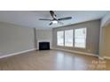 Inviting living room with a cozy fireplace, large windows for natural light, and wood-look flooring at 1007 Equipoise Dr, Indian Trail, NC 28079