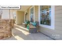 Inviting front porch with stone columns, comfortable seating, and stylish decor at 1010 Merganser Way, Indian Trail, NC 28079