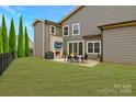 A spacious backyard features an outdoor dining area with stone fireplace, perfect for entertaining at 11327 James Coy Rd, Davidson, NC 28036