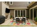 Stylish outdoor patio boasts a cozy dining setup, a built-in stone fireplace and inviting string lights at 11327 James Coy Rd, Davidson, NC 28036