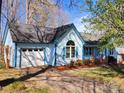 View of a charming light-blue home with white garage door, arched window and well-kept lawn at 121 Deertrack Dr, Mount Holly, NC 28120