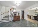 Inviting foyer featuring slate flooring, a wooden staircase, and views into the dining and living spaces at 1501 Laurel Ln, Gastonia, NC 28054