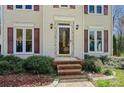 Close-up of the front entrance featuring a decorative glass door, brick steps, and classic exterior lighting at 207 Crossing Ave, Belmont, NC 28012