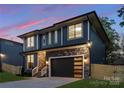 Striking home boasts a sleek, modern design, stylish garage door and attractive stone facade at 2969 Beech Nut Rd, Charlotte, NC 28208