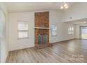 Bright living room showcasing a brick fireplace, high ceilings, and new flooring at 3701 Teaberry Ct, Charlotte, NC 28227