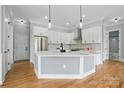 Modern kitchen with white cabinets, stainless steel appliances, and a large island with pendant lighting at 409 Henry Chapel Rd, Belmont, NC 28012