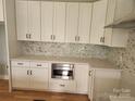 Modern kitchen with white cabinets, quartz countertops, stainless steel microwave, and stylish backsplash at 409 Henry Chapel Rd, Belmont, NC 28012