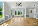 Spacious living area featuring hardwood floors, wainscoting, and abundant natural light at 409 Henry Chapel Rd, Belmont, NC 28012