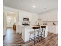 Stylish kitchen with white cabinetry, subway tile backsplash, and a center island with bar seating at 4211 Black Ct # 193, Harrisburg, NC 28075